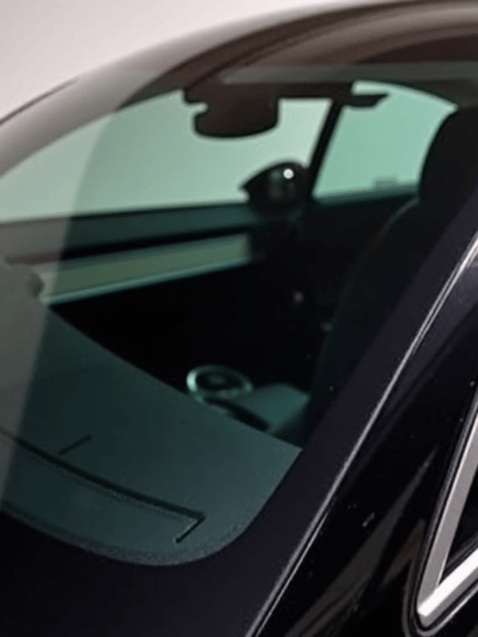 Autograff technician applying ceramic tint to a Tesla